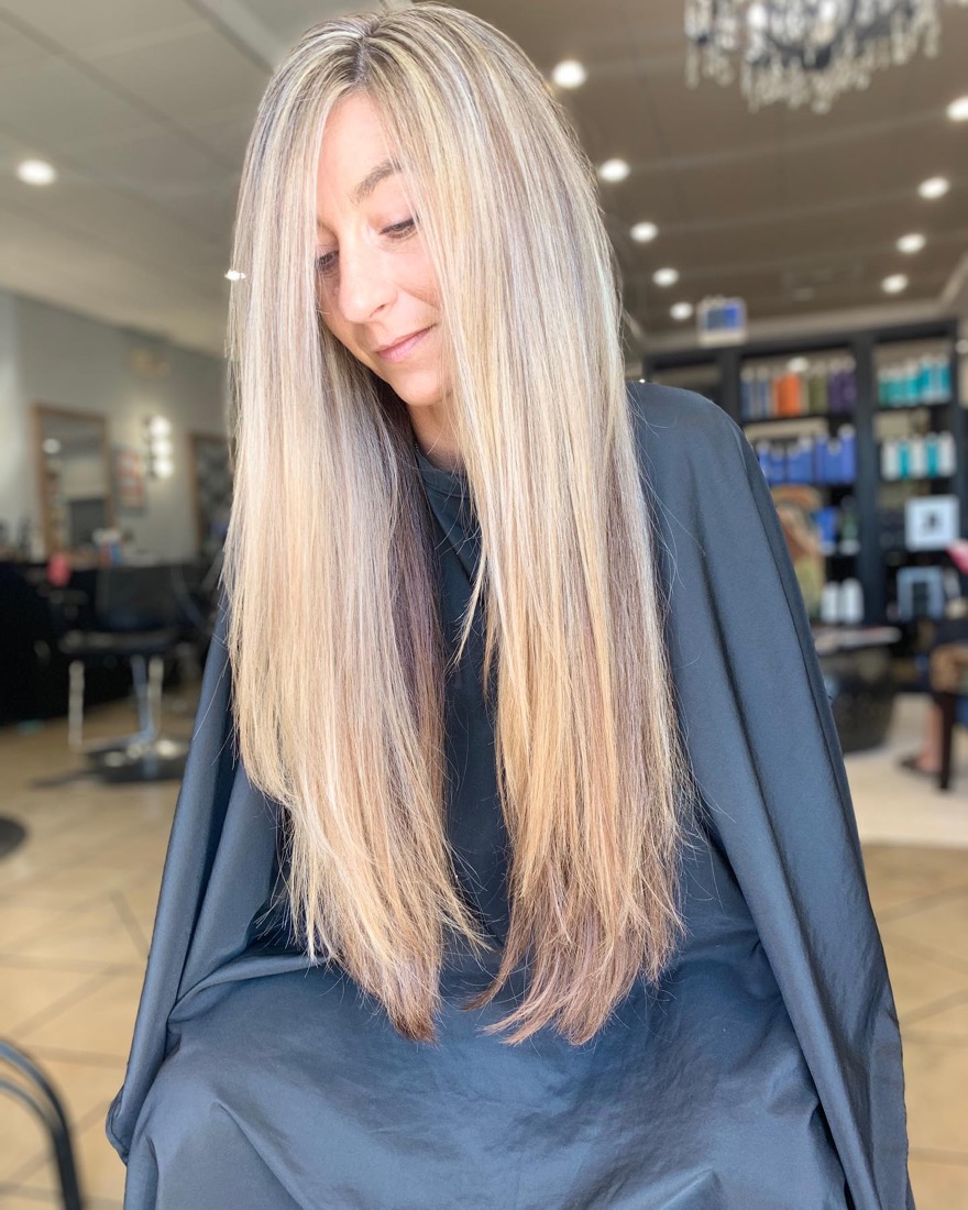 Client with long blonde balayage in the Ocean Curls chair