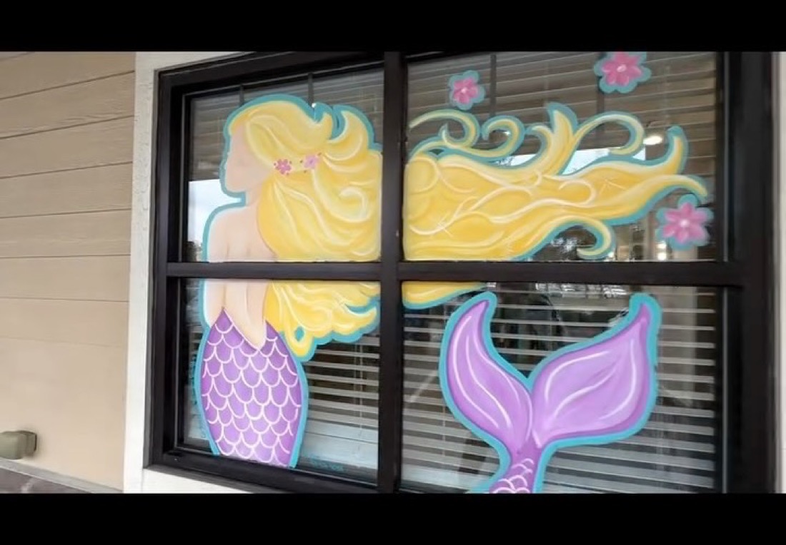 Hand-painted mermaid on the Ocean Curls Salon window